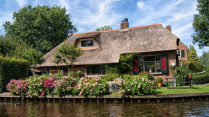 farmhouse by the water with blooming flowers